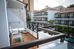 a balcony with a desk and a chair on a building at Vanilla Garden Boutique Hotel - Adults Only in Playa de las Americas