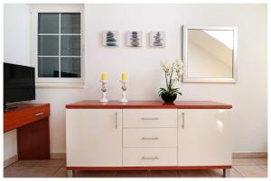 a white cabinet with two candles and a mirror at Apartments Jerko in Primošten