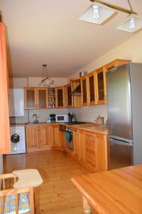 a kitchen with wooden cabinets and a stainless steel refrigerator at Słoneczne Chaty pod Sonami Kasina Wielka in Kasina Wielka