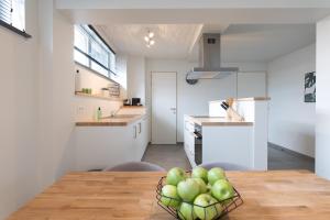 Raveel Lofts في دينزة: مطبخ مع طاولة مع وعاء من التفاح عليه