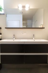 uma casa de banho com 2 lavatórios e um espelho em Raveel Lofts em Deinze