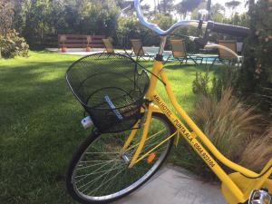 a yellow bike with a basket parked on a sidewalk at Arli Hotel Hideaway Punta Ala - Adults Only in Punta Ala