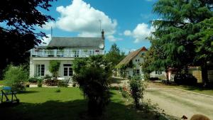 a white house with a palm tree in front of it at O tour du monde in Cellettes