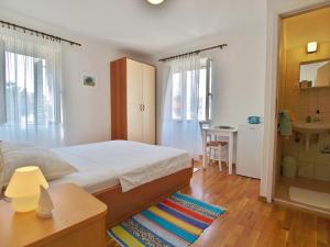 a bedroom with a bed and a bathroom at Rooms and Studio Old Town in Rab