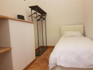 a bedroom with a white bed and a black spotlight at Large Flat City Centre in Milan