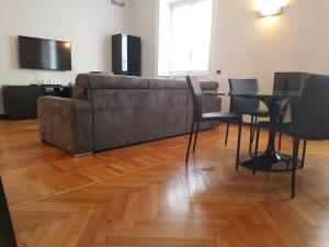 Large Flat City Centre في ميلانو: غرفة معيشة مع أريكة وطاولة وكراسي
