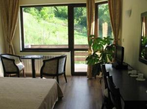 a bedroom with a table and chairs and a large window at Villa Cherven in Teteven