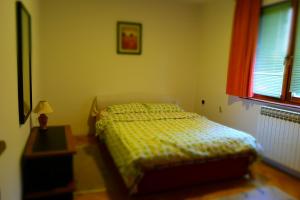 a bedroom with a bed and a table and a window at Villa AMANI in Sarajevo