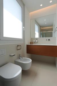 a bathroom with a toilet and a sink and a mirror at Mediterranean View in Marina di Ragusa +20 photos