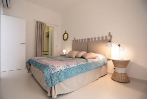 a white bedroom with a bed and a lamp at Mediterranean View in Marina di Ragusa