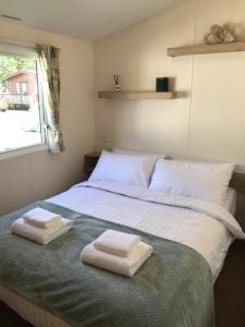 ein Schlafzimmer mit einem Bett mit zwei Handtüchern darauf in der Unterkunft Edinburgh, Seton Sands in Port Seton
