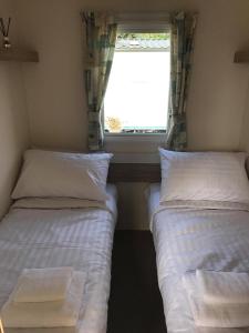 two beds in a small room with a window at Edinburgh, Seton Sands in Port Seton