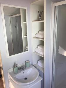 ein Badezimmer mit einem Waschbecken, einem Spiegel und Handtüchern in der Unterkunft Edinburgh, Seton Sands in Port Seton