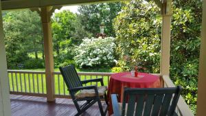 porche con mesa roja y 2 sillas en Hummingbird Inn en Goshen