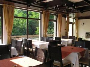 a dining room with tables and chairs and windows at Villa Cherven in Teteven