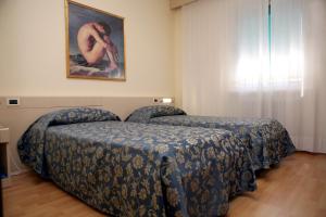 sypialnia z 2 łóżkami i obrazem na ścianie w obiekcie Hotel Excelsior w mieście Monfalcone