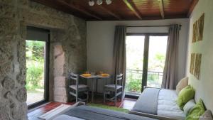 ein Zimmer mit einem Bett und einem Tisch mit Stühlen in der Unterkunft Casa do Contador T3 / T6 in Vieira do Minho