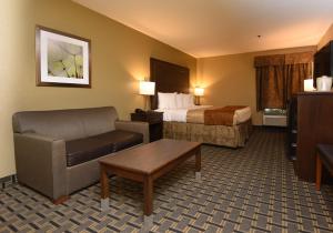 een hotelkamer met een bed en een bank bij Best Western Zachary Inn in Zachary