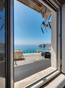 a window with a view of the ocean at The Beachfront Dubrovnik Old Town in Dubrovnik