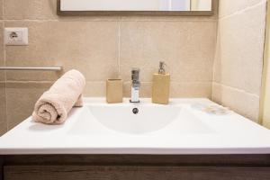 a bathroom sink with a towel on top of it at Suite Cagliaritane Notti in centro in Cagliari