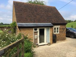 a small brick house with a window and a fence at Eydon B&B in Daventry