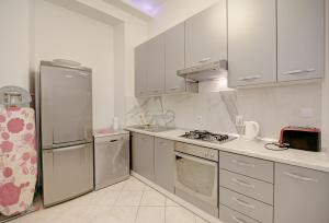 a kitchen with white cabinets and stainless steel appliances at The Beachfront Dubrovnik Old Town in Dubrovnik