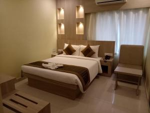 a bedroom with a large bed and a chair at Buddha Imperial in Muzaffarpur