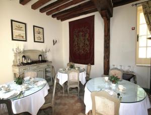 uma sala de jantar com duas mesas com toalhas de mesa brancas em Château de Maudetour em Maudétour-en-Vexin