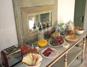 - une table remplie d'aliments pour le petit-déjeuner et de jus d'orange dans l'établissement Château de Maudetour, à Maudétour-en-Vexin