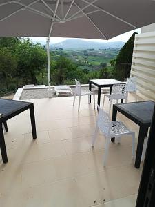 a patio with tables and chairs and an umbrella at Residenza Skanderbeg in Montecilfone