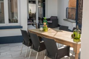 a wooden table with chairs and bottles on a patio at Ferienhaus am Kloster Stuben in Bremm