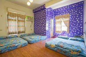 two beds in a room with purple walls at Ji Xiang in Xiaoliuqiu