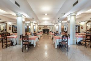 ein Restaurant mit Tischen und Stühlen in einem Zimmer in der Unterkunft Hotel Michelangelo in Sassuolo