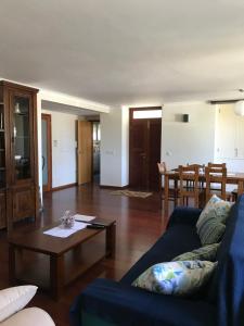 a living room with a blue couch and a table at Silveira by the Sea in Angra do Heroísmo