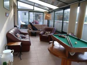 ein Wohnzimmer mit einem Billardtisch und Sofas in der Unterkunft Domisiladore in Le Molay-Littry