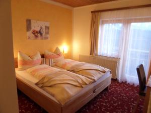 a bedroom with a large bed with a window at Gästehaus ERLE in Ramsau am Dachstein