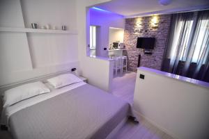 a bedroom with a white bed and a brick wall at Zadar Sweet Studios in Zadar