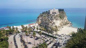 a crowd of people on a beach with a castle at Chez Moi Tropea Centro in Tropea