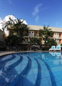 a large swimming pool with chairs and a building at Augustu's Hotel in Altamira