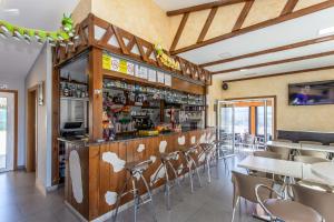 a bar in a restaurant with tables and chairs at Albergue Milpés in Ribadiso