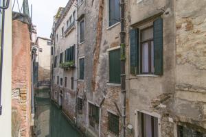 eine Gasse in einem alten Gebäude mit Fenstern in der Unterkunft Love Gentile in Venedig