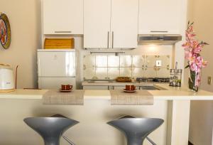 a kitchen with a counter with three stools at Blue Wood Apartment in Letojanni