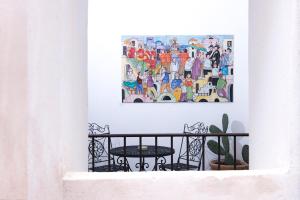 un dipinto appeso a un muro accanto a un tavolo di DieciSedici ad Amalfi