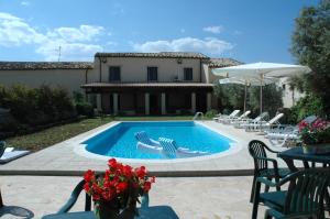 una piscina con sillas y una casa en San Domenico Residence en Arenella