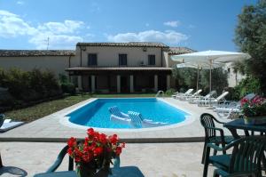 a swimming pool with chairs and a house at San Domenico Residence in Arenella