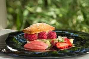 a plate of food with raspberries and fruit on it at Hôtel-Restaurant Ricordeau in Loué