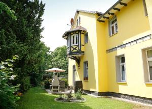 una casa gialla con una luce sul lato di Haus Eveline - Ferienwohnungen unterhalb der Wartburg - a Eisenach