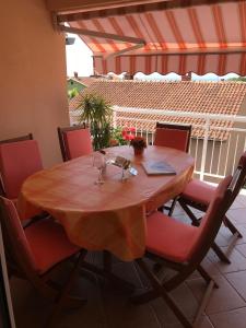 a wooden table with red chairs and a table with wine glasses at House Marić in Poreč