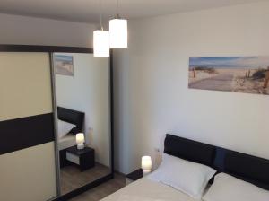 a bedroom with a bed and a large mirror at Bluewaves Apartment Mamaia Nord in Mamaia Nord