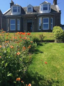 uma casa com flores de laranja em frente em Dupplin152 bed and breakfast em Dundee